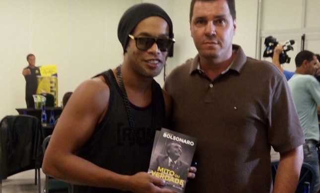 Divulgação/Ronaldinho com o livro de Jair Bolsonaro.