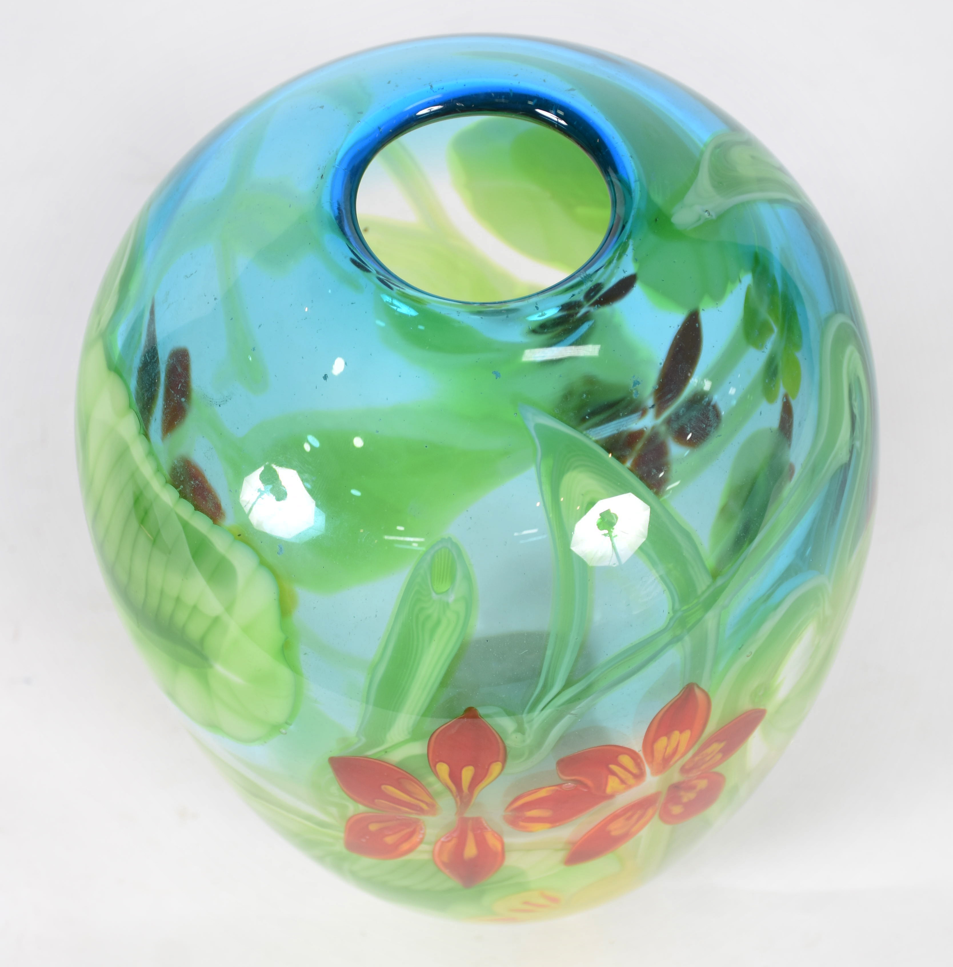 Jarra de vidro transparente em tons de verde e azul com flores em... - foto 2 de 3