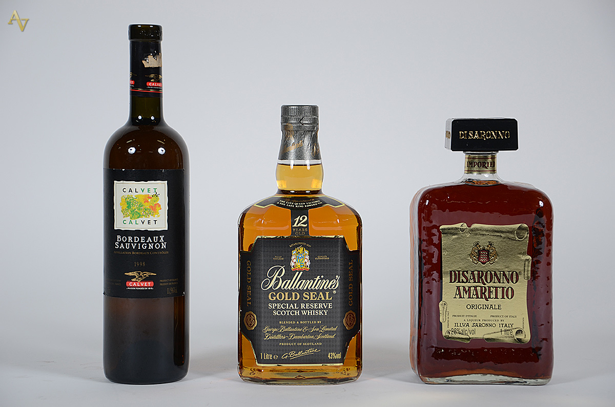 Tres bebidas, sendo: whisky Ballatine's, licor Amaretto e vinho... - foto 1 de 2