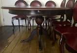 Mesa de jantar de madeira nobre, tampo feitio o... - Mesa de jantar de madeira nobre, tampo feitio oval (com tábua extensora), apoio sobre coluna balaústre terminando em quatro pernas recurvas e po...