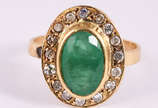 Anel de ouro amarelo 18 k. com 1 esmeralda e 20... - Anel de ouro amarelo 18 k. com 1 esmeralda e 20 brilhantes, aro 19. (por questão de segurança a peça não se encontra na loja)
