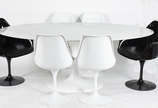 Mesa oval "Saarinen" com tampo de mármore e 6 c... - Mesa oval "Saarinen" com tampo de mármore e 6 cadeiras giratórias de fibra, sendo 4 na cor branca e duas com braços na cor preta.