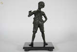 Estatueta de petit bronze representando menino.... - Estatueta de petit bronze representando menino. Altura total 43 cm.