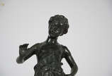 Estatueta de petit bronze representando menino.... - Estatueta de petit bronze representando menino. Altura total 43 cm.