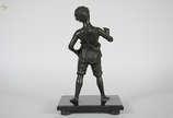 Estatueta de petit bronze representando menino.... - Estatueta de petit bronze representando menino. Altura total 43 cm.