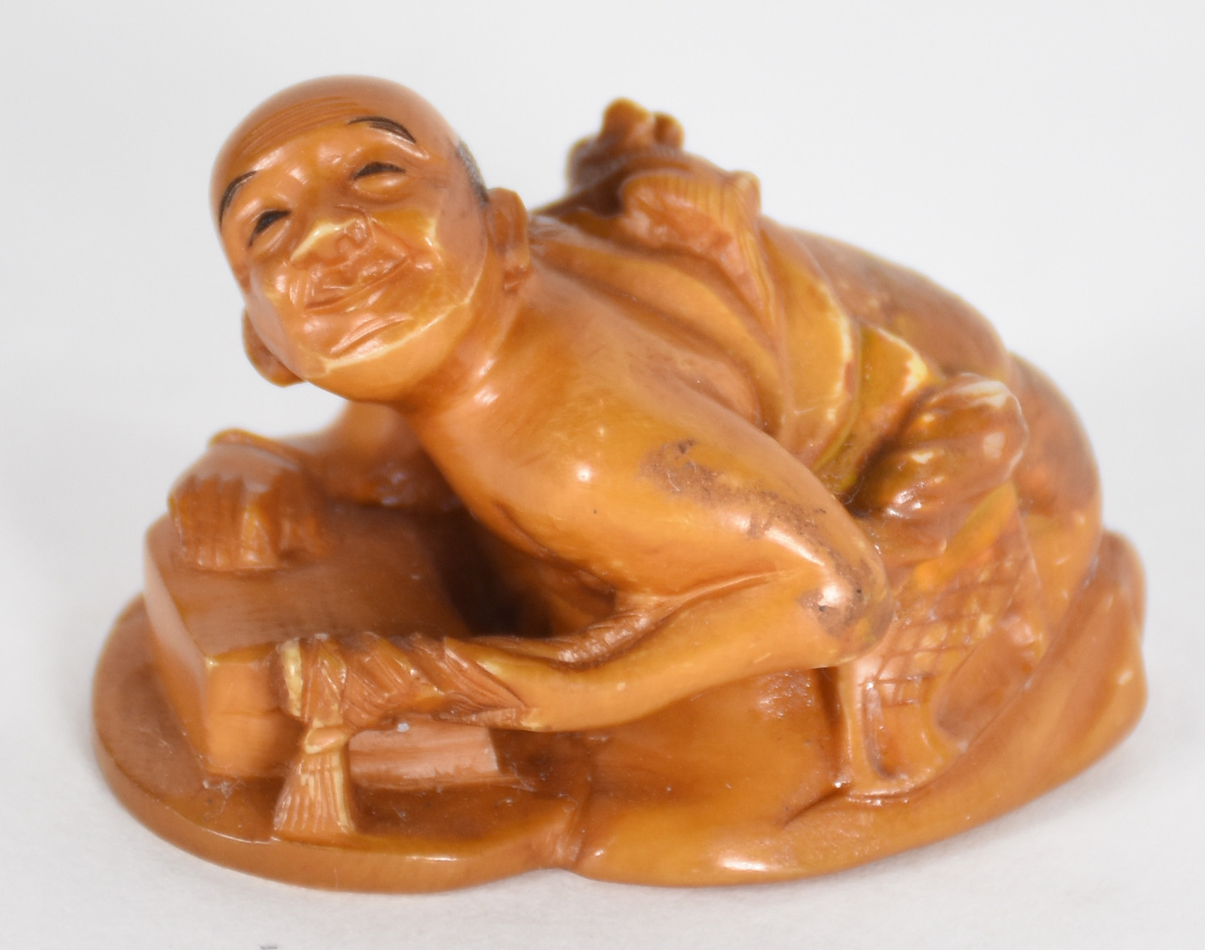 Netsuke de marfim representando figura com bichinho nas costas... - foto 1 de 4