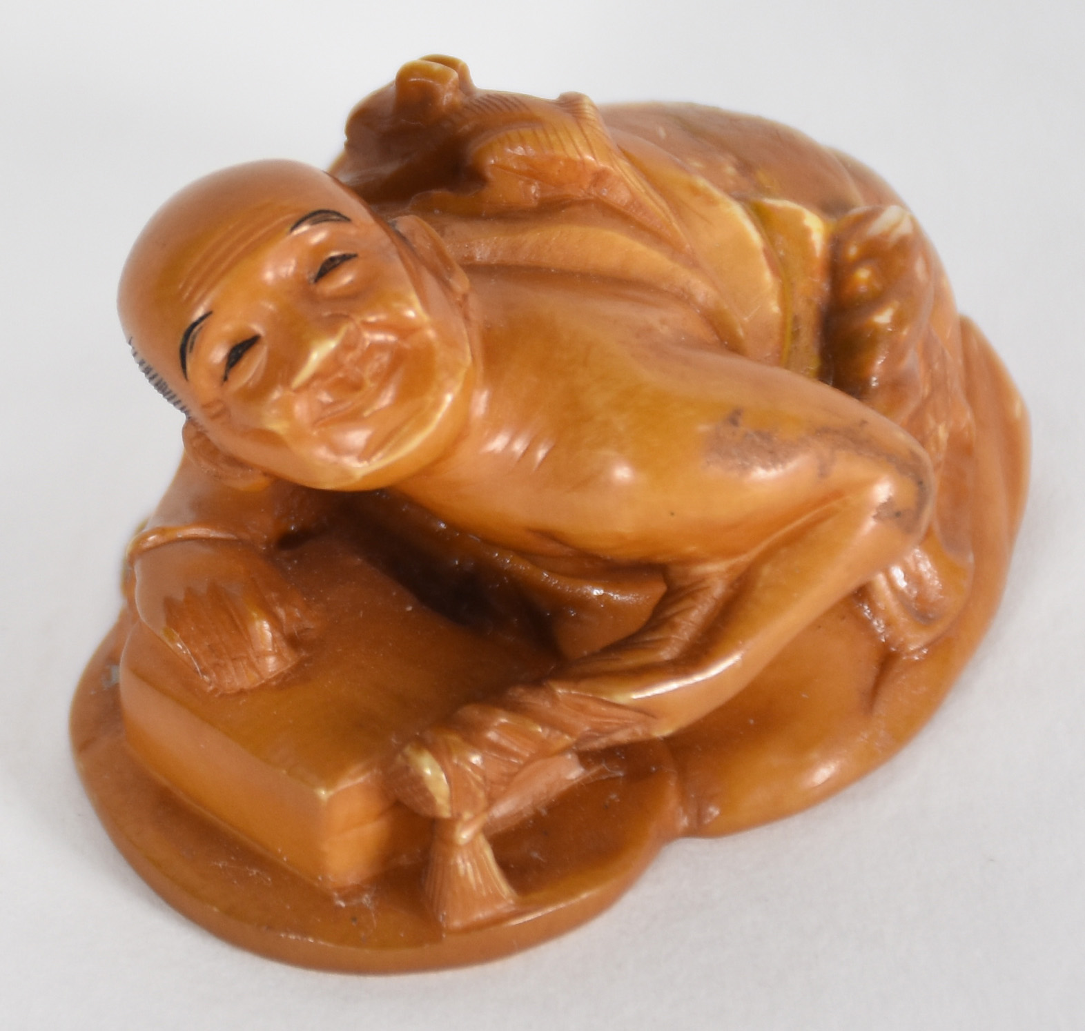 Netsuke de marfim representando figura com bichinho nas costas... - foto 2 de 4
