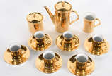 Pequeno serviço de café de porcelana dourada co... - Pequeno serviço de café de porcelana dourada composto de 6 xícaras com pires, bule, leiteira e açucareiro.