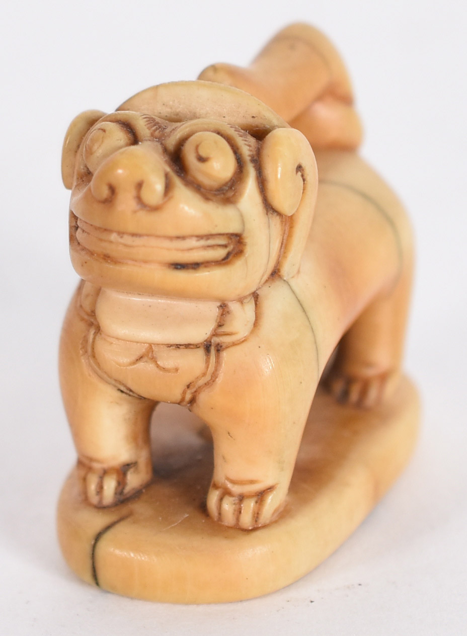 Netsuke em marfim no formato de Cão de Fó, gravado com ideogama na... - foto 1 de 4