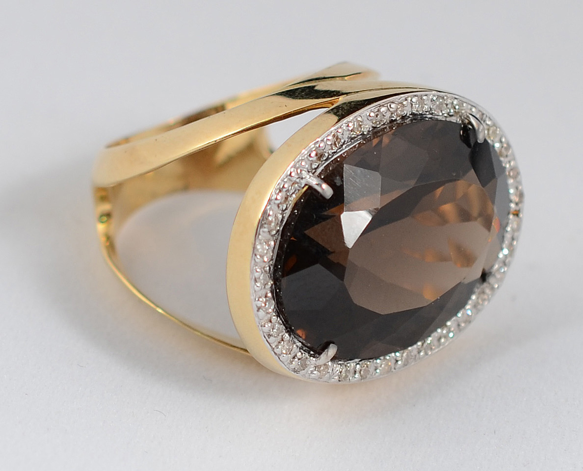 Anel de ouro 18 k, com pedra fume lapidação oval facetada, contornada... - foto 1 de 2