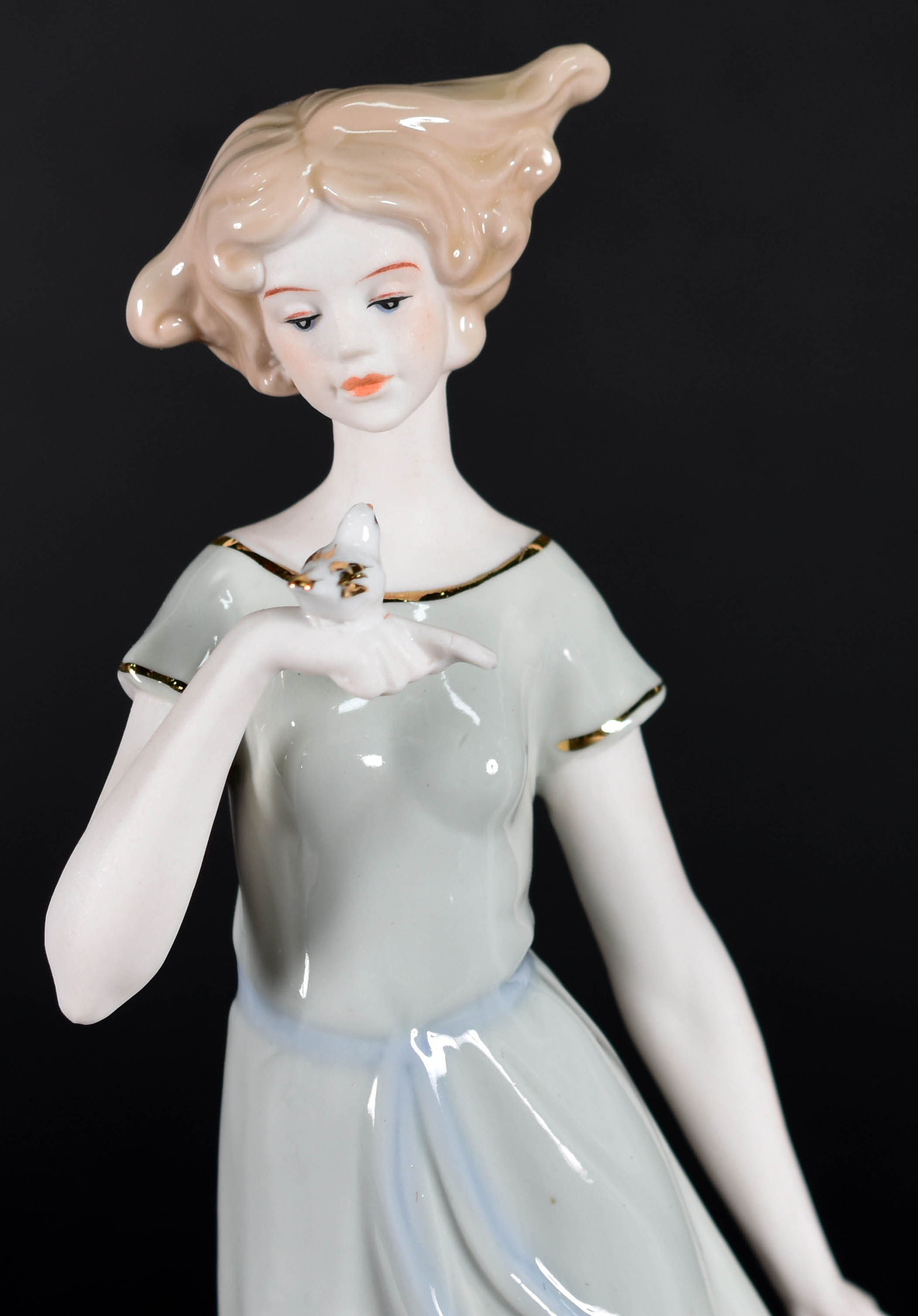 Escultura de porcelana representando dama com pássaro. - foto 1 de 4