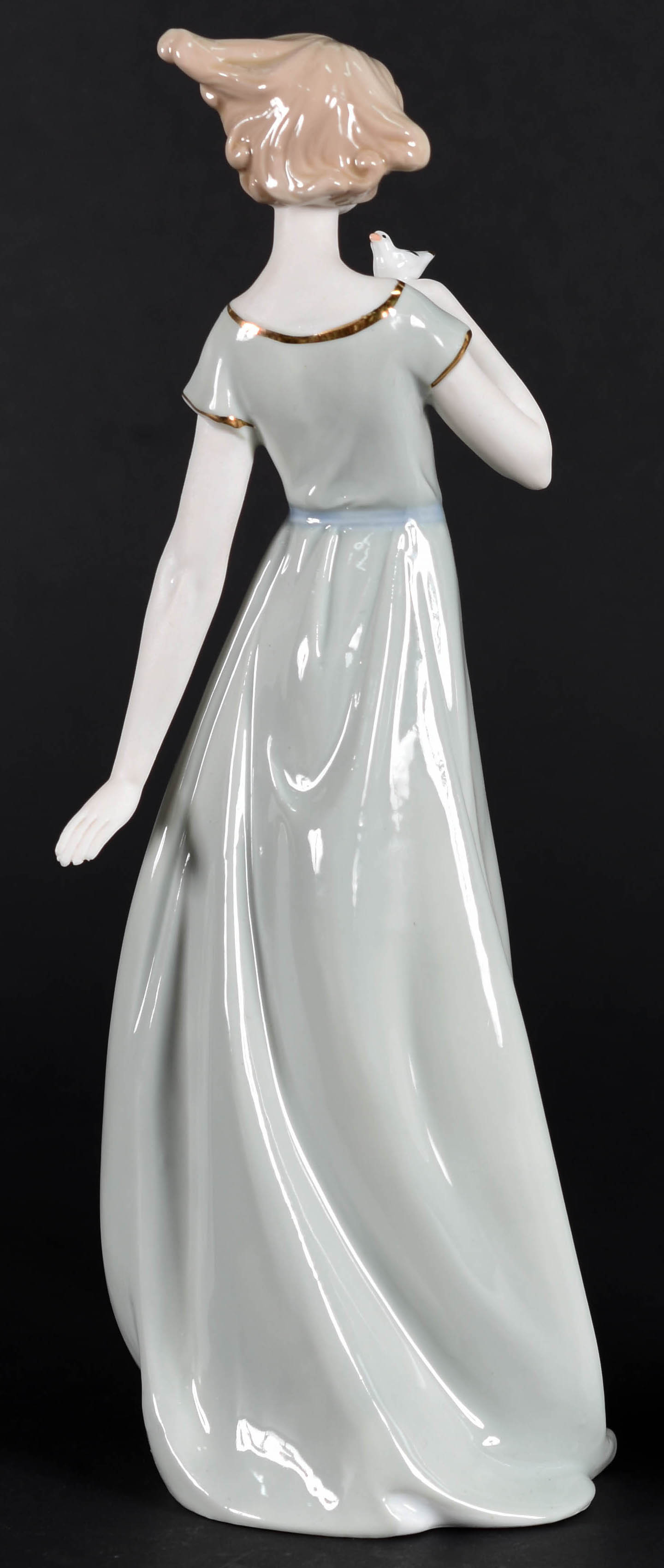 Escultura de porcelana representando dama com pássaro. - foto 3 de 4