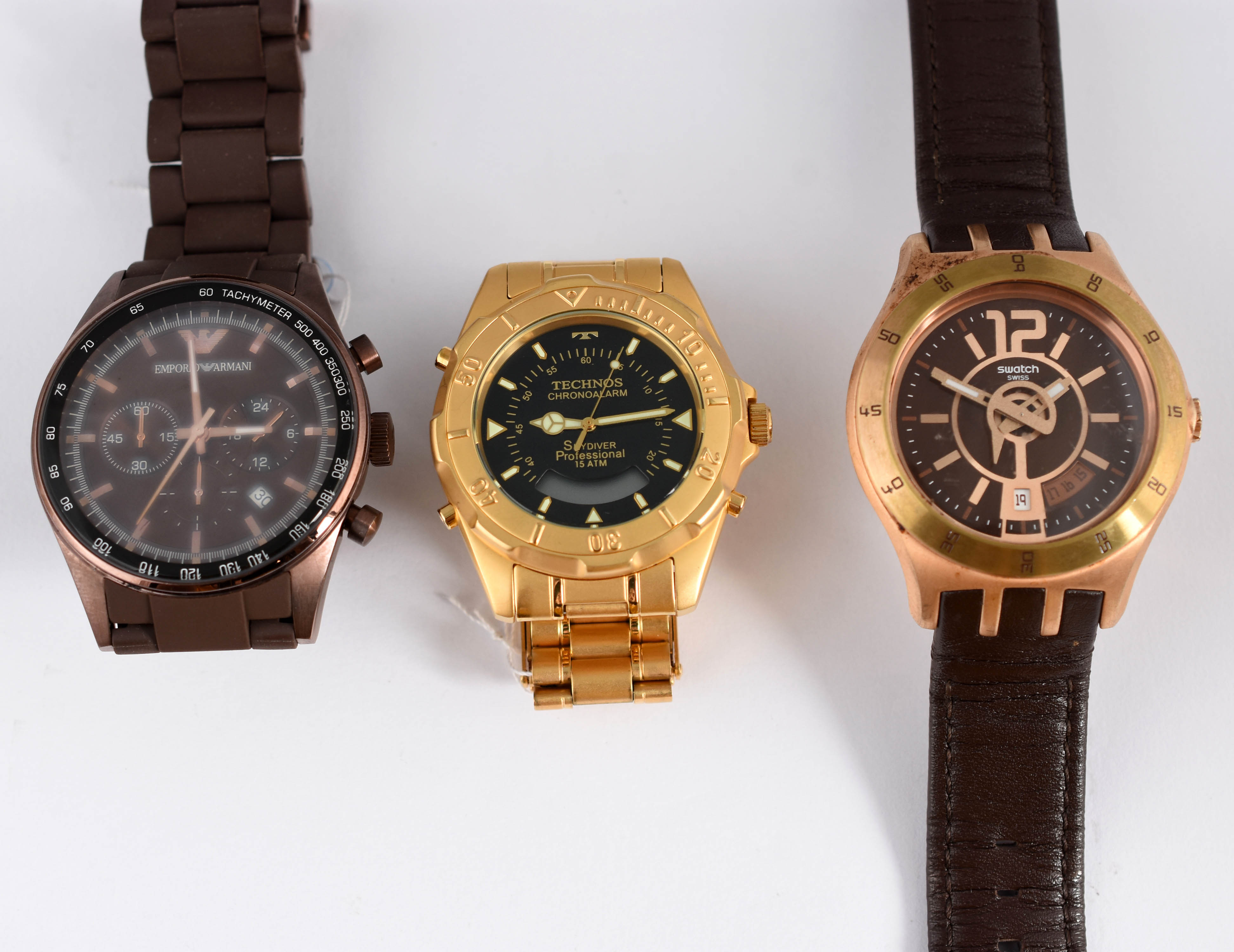 Três relógios sendo, 1 Empório Armani, 1 Technos, e 1 Swatch. - foto 1 de 7