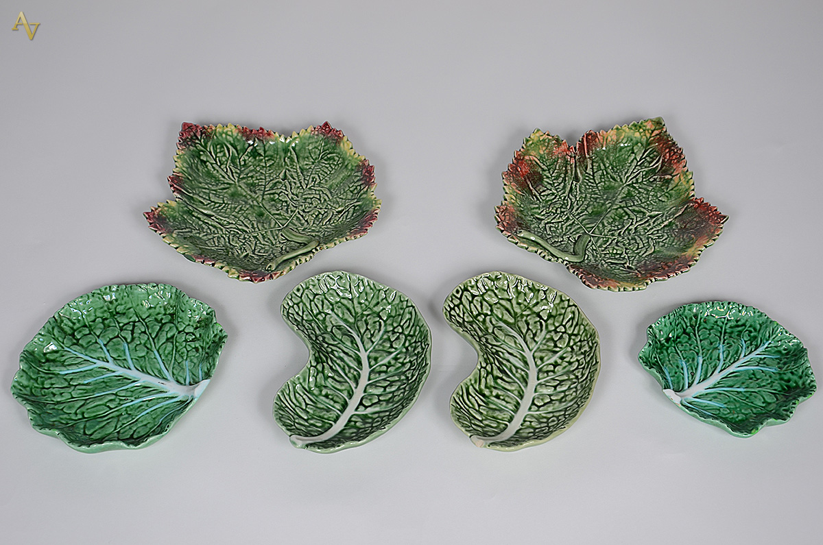 Seis pratos de faiança portuguesa verde no feitio de folhas, tamanhos...
