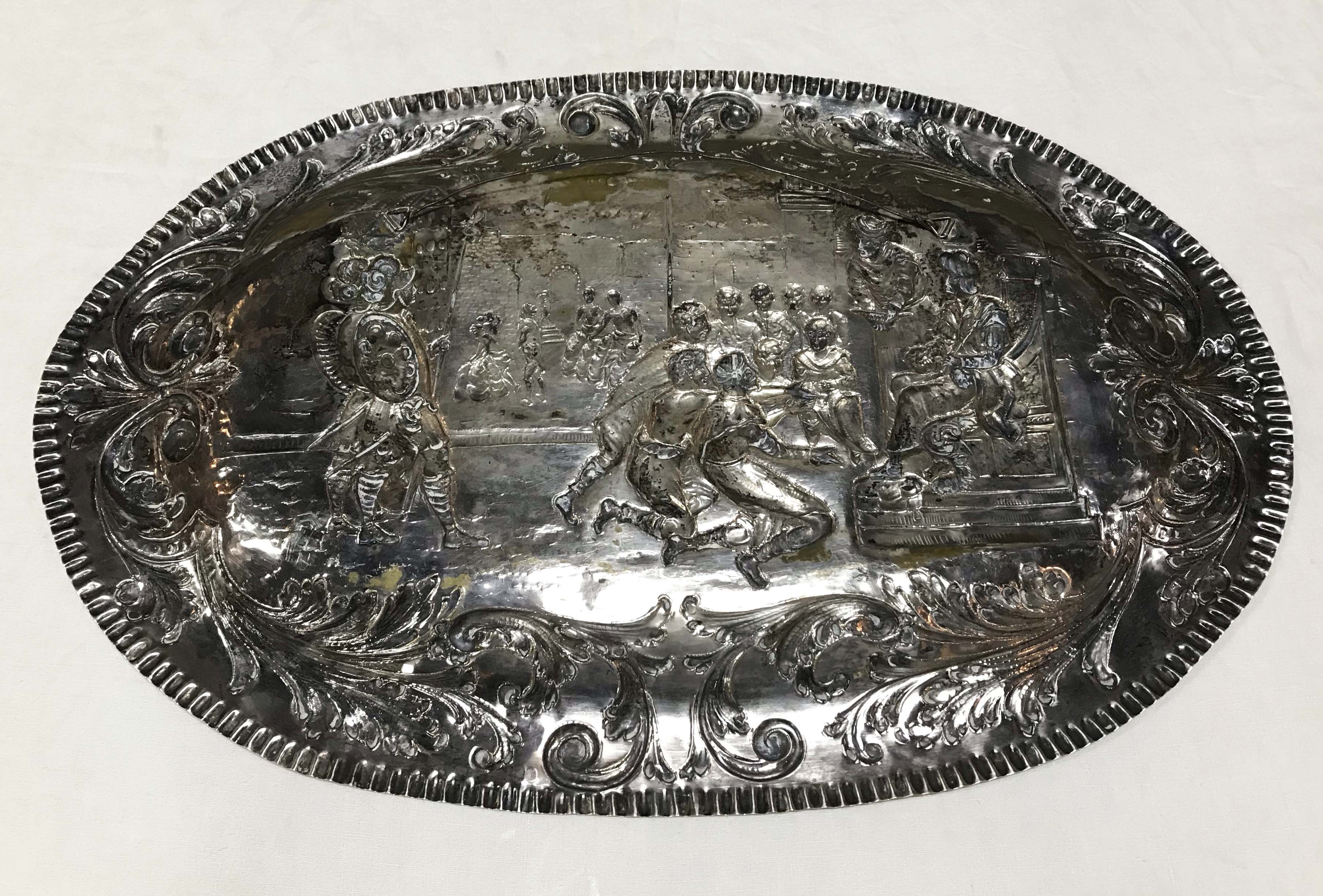 Medalhão oval de prata contrastada, com cenas de guerreiros em relevo. - foto 2 de 3