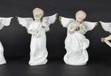 Conjunto com quatro estatuetas de porcelana bra... - Conjunto com quatro estatuetas de porcelana branca com frisos dourados representando anjos musicistas.