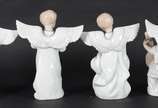 Conjunto com quatro estatuetas de porcelana bra... - Conjunto com quatro estatuetas de porcelana branca com frisos dourados representando anjos musicistas.