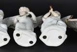 Conjunto com quatro estatuetas de porcelana bra... - Conjunto com quatro estatuetas de porcelana branca com frisos dourados representando anjos musicistas.