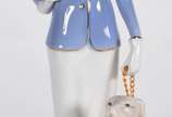 Estatueta de porcelana policromada representand... - Estatueta de porcelana policromada representando figura feminina com cachorro.