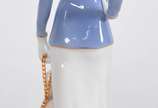 Estatueta de porcelana policromada representand... - Estatueta de porcelana policromada representando figura feminina com cachorro.
