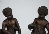 Duas estatuetas de bronze representando figura ... - Duas estatuetas de bronze representando figura feminina e menino com taça, bases de mármore. Alturas 27 cm.