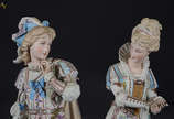 Par de figuras de biscuit europeu policromado r... - Par de figuras de biscuit europeu policromado repres. Casal de nobres, uma delas com restauro na base e faltando alguns dedinhos. Altura 49 cm.