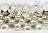 Aparelho de chá, café e jantar de porcelana KPM... - Aparelho de chá, café e jantar de porcelana KPM bege com frisos dourados composto de: Treze pratos rasos, doze pratos fundos, dez pratos de sobr...