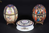 Tres peças de porcelana diversas, sendo dois ov... - Tres peças de porcelana diversas, sendo dois ovos ao gosto Fabergé e uma caixa redonda. Alturas dos ovos 22 cm e caixa com 16 cm de diâmetro e 5...