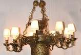 Grande lustre de bronze para nove luzes externa... - Grande lustre de bronze para nove luzes externas e duas internas, ricamente trabalhado com florões e vazados.