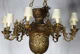 Grande lustre de bronze para nove luzes externa... - Grande lustre de bronze para nove luzes externas e duas internas, ricamente trabalhado com florões e vazados.