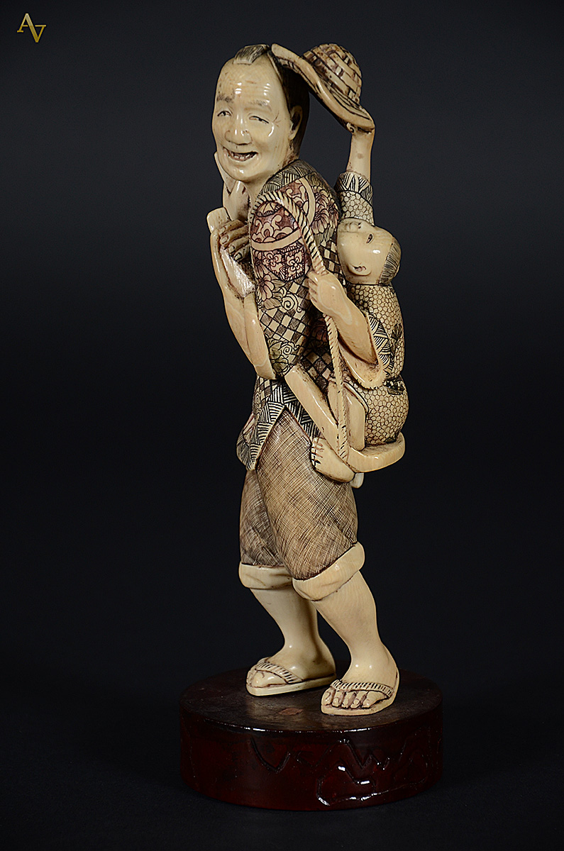 Escultura de marfim representando homem japonês carregando menino... - foto 1 de 2