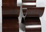 Par de banquetas de madeira no feitio de dois s... - Par de banquetas de madeira no feitio de dois semi-círculos, almofada solta estofada e forrada em couro.