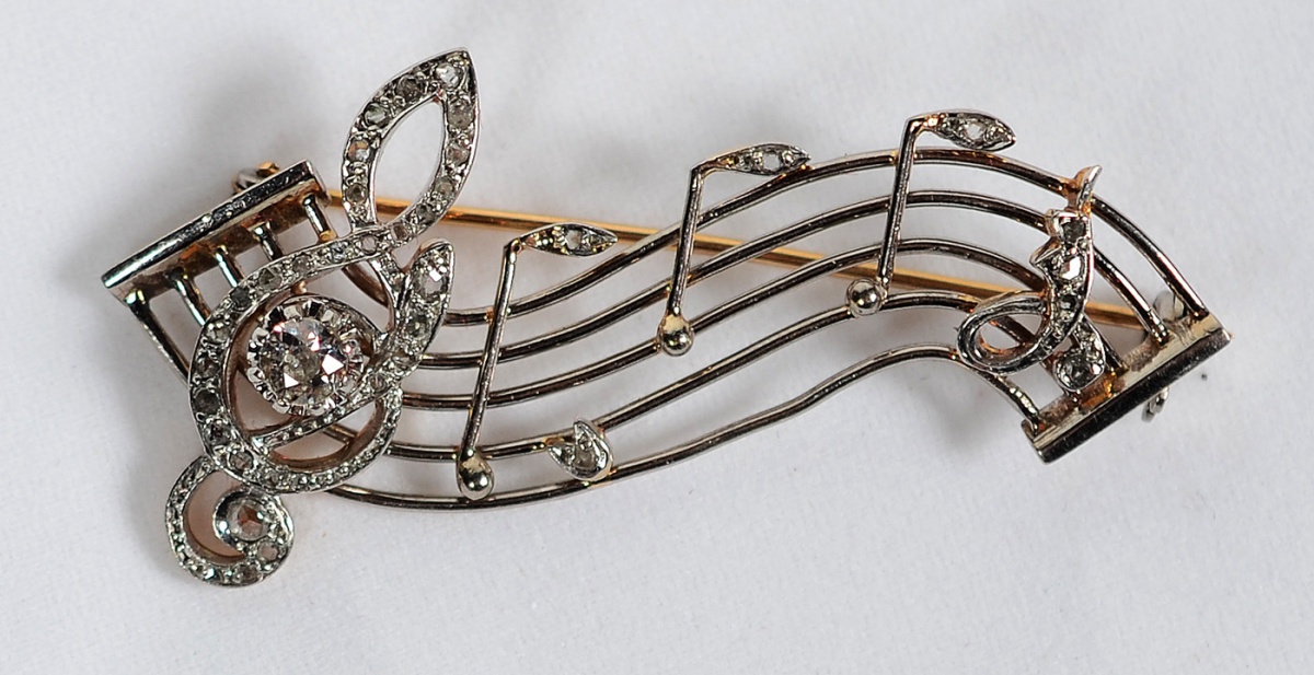 Broche em formato de clave de sol com platina - ouro e diamantes