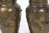Par de vasos de bronze oriental com aves e folh... - Par de vasos de bronze oriental com aves e folhagens em relevo, bases de madeira.
