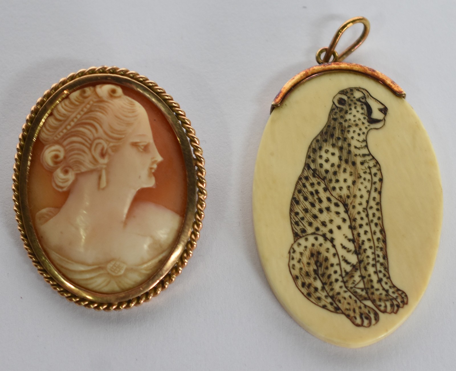 Dois broches sendo um camafeu de coral e um de marfim com bordas de... - foto 1 de 3