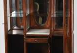 Móvel vitrine de madeira nobre parquetada com d... - Móvel vitrine de madeira nobre parquetada com duas portas laterais com vidros ovais bisotados, prateleiras internas, parte central com portinha ...