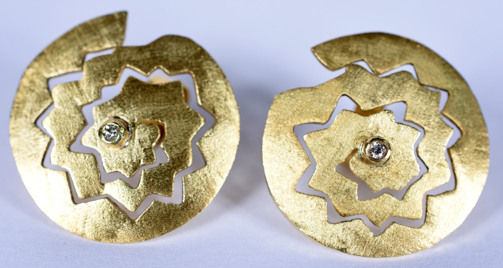 Par de brincos em ouro 18 k fosqueados e vazados com um diamante no... - foto 1 de 3