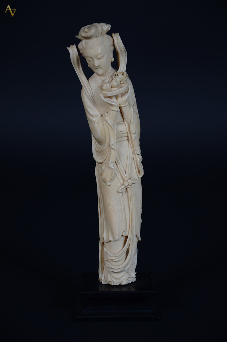 Estatueta de marfim representando gueixa com flores, base de madeira...