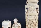 Duas estatuetas de marfim, sendo um vaso trabal... - Duas estatuetas de marfim, sendo um vaso trabalhado com figuras e aves em relevo (pequena parte faltando na borda) e, grupo escultórico represen...