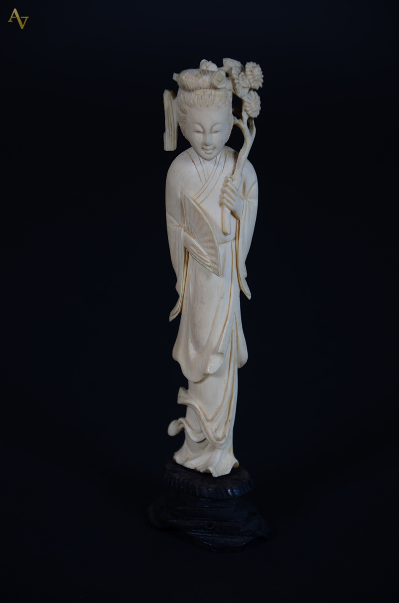 Estatueta de marfim representando gueixa com flores, base de madeira...