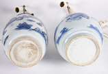 Dois abatjoures em porcelana oriental azul e br... - Dois abatjoures em porcelana oriental azul e branco, modelos diferentes, cúpulas na cor bege e bases de madeira. Século XIX. Altura só da porcel...