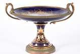 Fruteira de porcelana francesa de Sèvres e apli... - Fruteira de porcelana francesa de Sèvres e aplicações de bronze com cenas de ninfas em policromia, borda azul cobalto com guirlandas douradas, a...