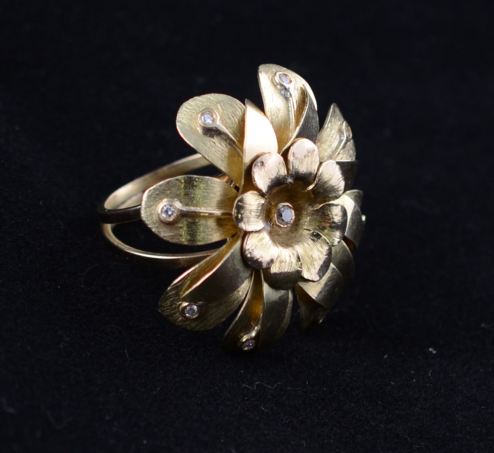 Anel de ouro amarelo em forma de flor c/ nove brilhantes. Peso:14 g...