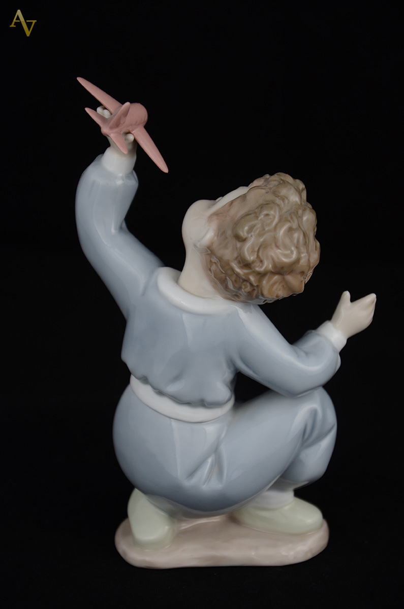 NAO - Escultura em porcelana representando menino c/ avião. Altura... - foto 2 de 2