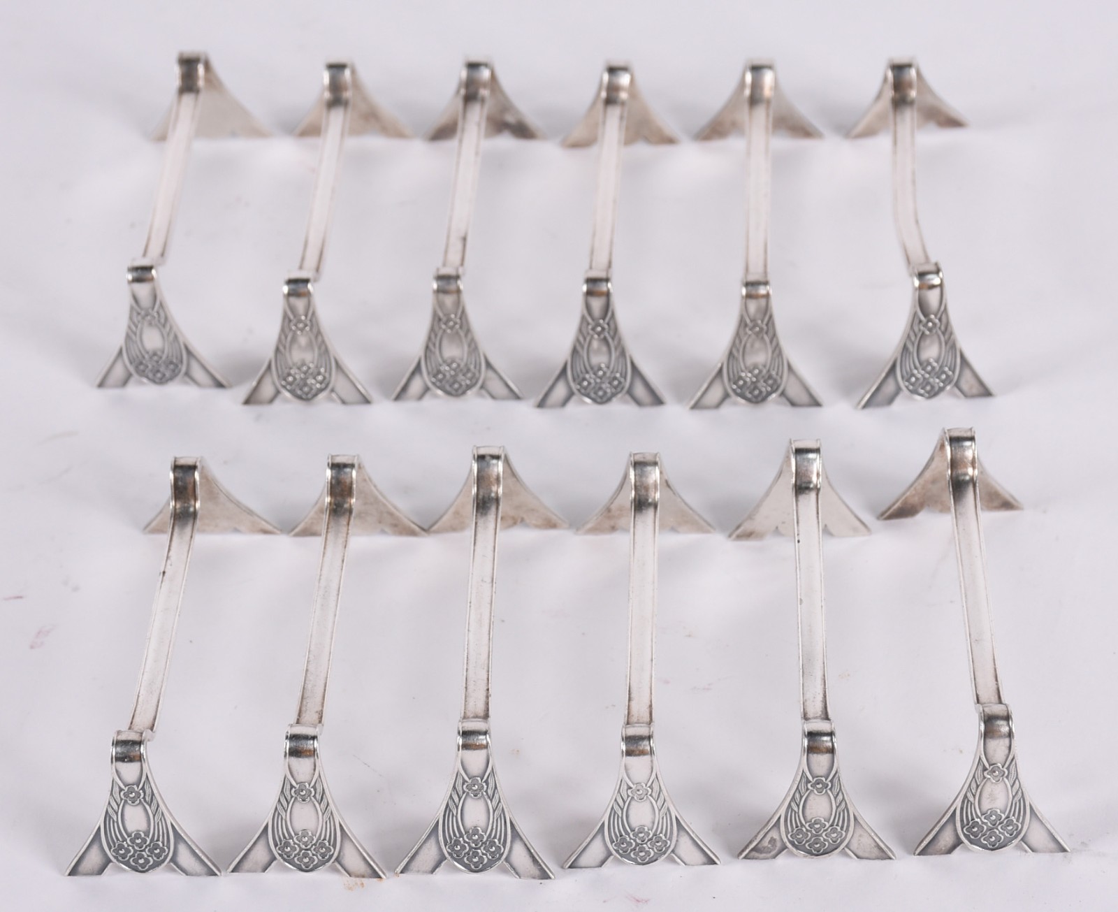 Conjunto com 12 suportes para talheres de metal prateado. - foto 1 de 2