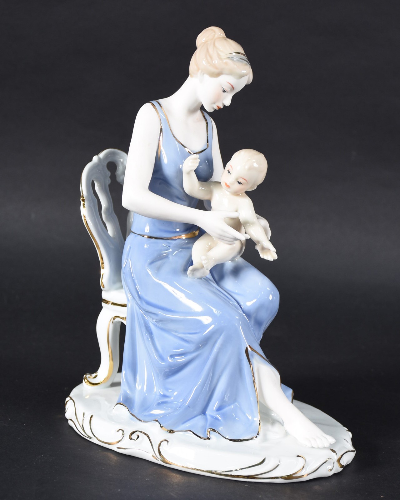 Grupo escultórico de porcelana representando mãe com bebê. - foto 1 de 5