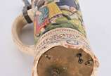Tankard musical de cerâmica com figuras em rele... - Tankard musical de cerâmica com figuras em relevo policromado, tampa de estanho, com bicado na base.