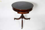 Mesa auxiliar de madeira nobre, estilo ingles, ... - Mesa auxiliar de madeira nobre, estilo ingles, um dos pés com restauro. Tampo de couro pirogravado, sobre rodízios. (diam. 69 alt. 71 cm).