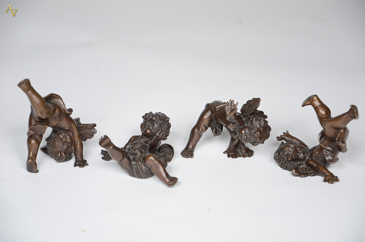 Conjunto com quatro pequenas esculturas de bronze representando anjos...