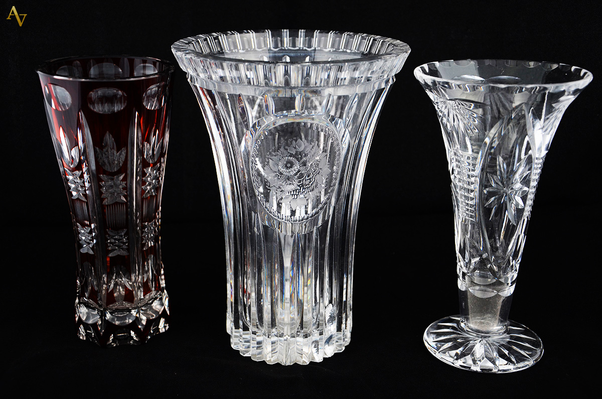 Três vasos diversos de cristal - um com frisos e medalhão lavrado com...